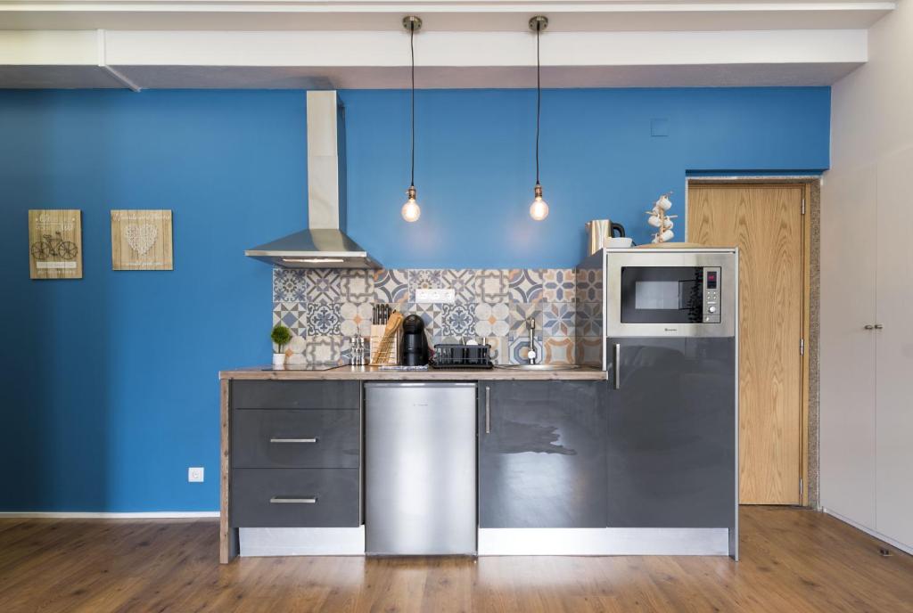 een keuken met een roestvrijstalen koelkast en een magnetron bij Sta Catarina - 2 Bedroom Apartament in Porto