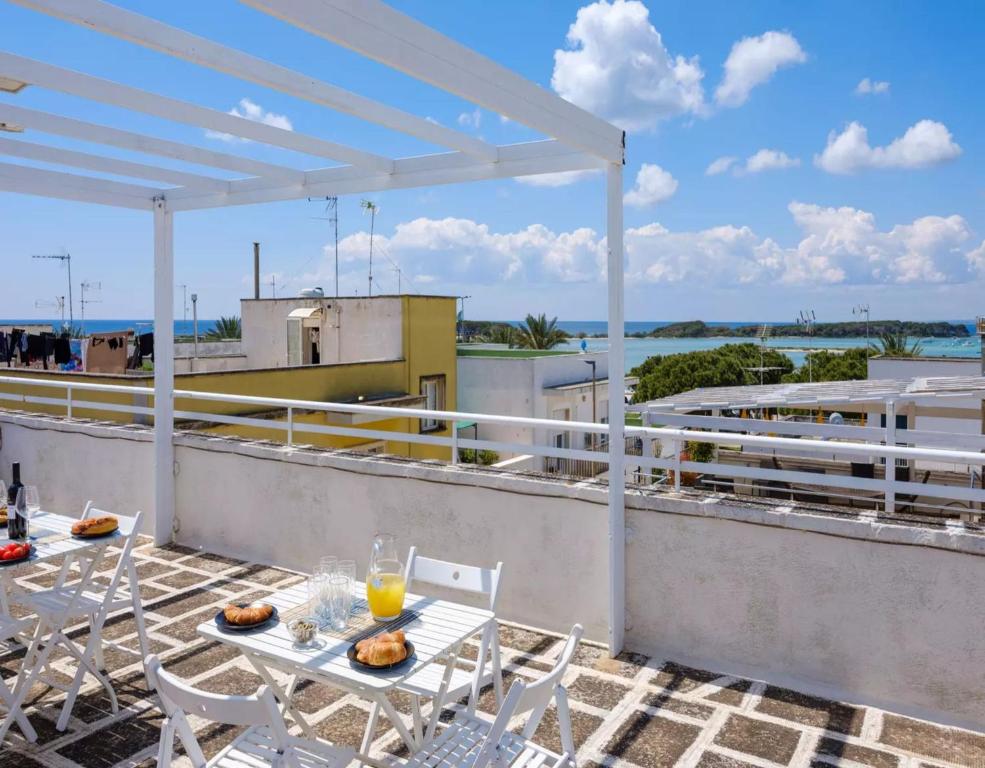 a patio with a table and chairs on a roof at Belvedere Luxury Seafront With Panoramic Terrace in Porto Cesareo