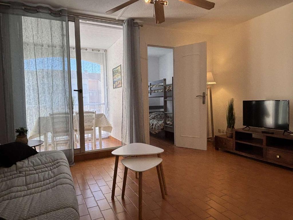 un salon avec un canapé et une télévision dans l'établissement Appartement 2 pièces cabine 4 couchages ARGELES SUR MER AR020-207, à Argelès-sur-Mer