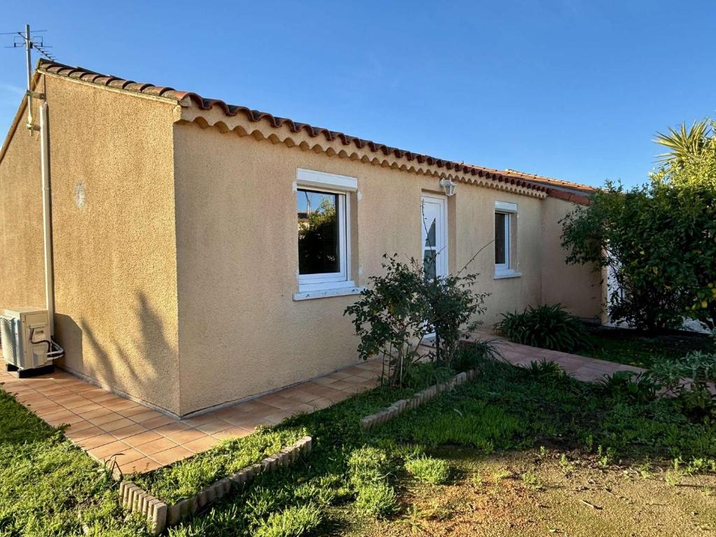 une petite maison avec un jardin en face de celle-ci dans l'établissement Maison 3 pièces avec jardin et terrasse - Jusqu'à 4 personnes - ARGELES SUR MER AR000-014, à Argelès-sur-Mer