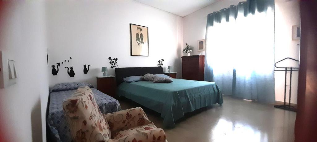 una camera da letto con un letto e una sedia di La comodità a due passi dal mare di Mondello a Mondello