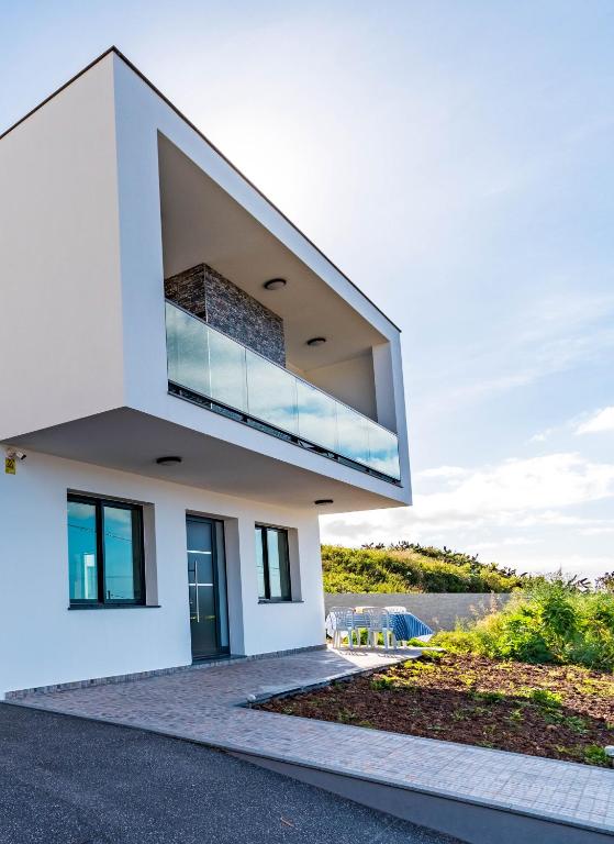a white house with a large window on it at Casa Luciano in Estreito da Calheta
