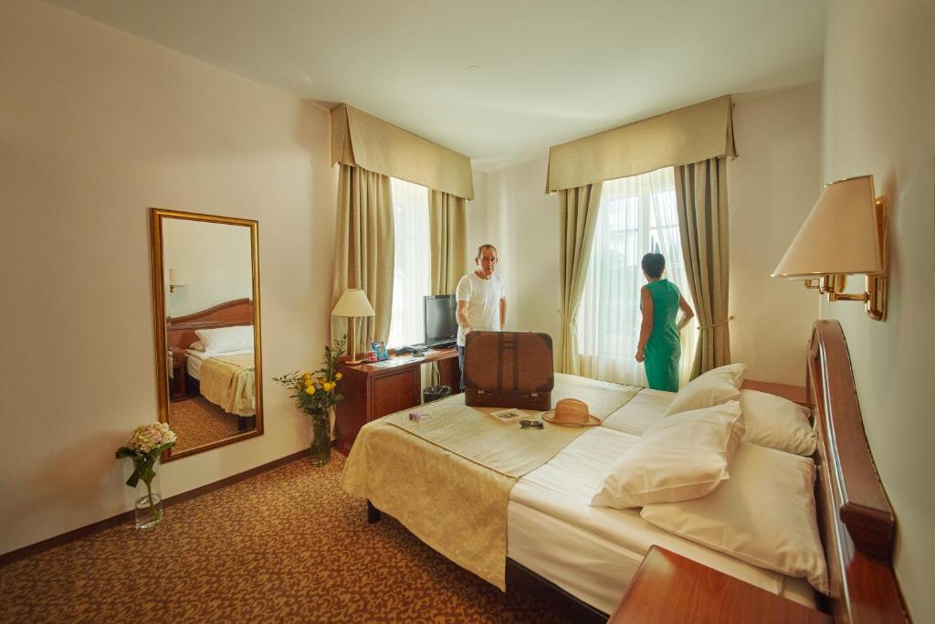 a woman is standing in a hotel room at Hotel Convent - Hotel & Resort Adria Ankaran in Ankaran