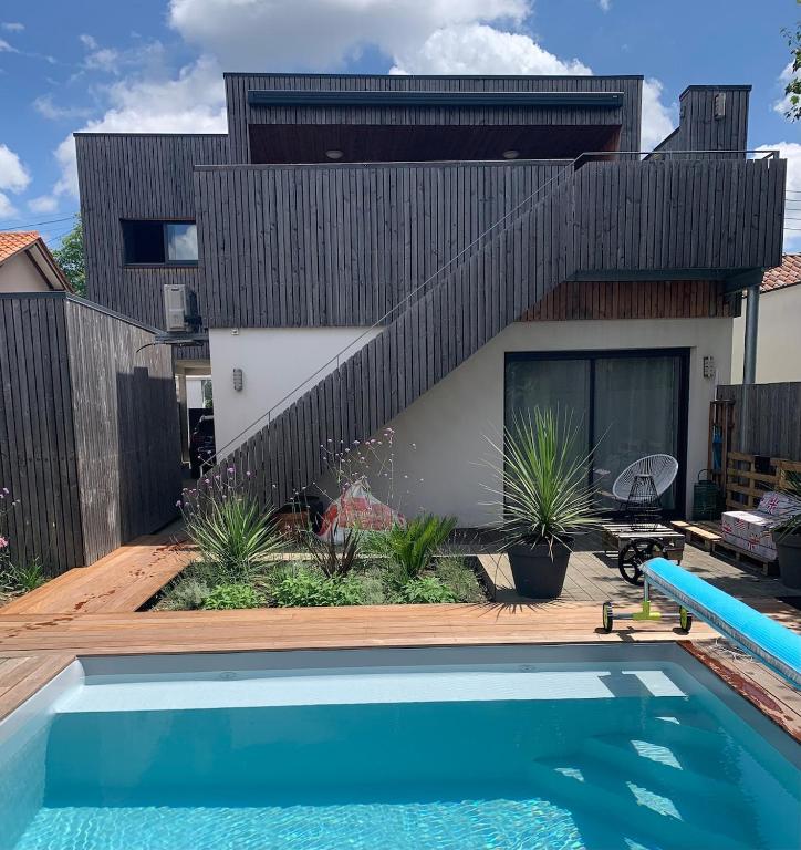 podwórko z basenem i domem w obiekcie Maison avec piscine à 10 min du centre de Bordeaux w mieście Bègles