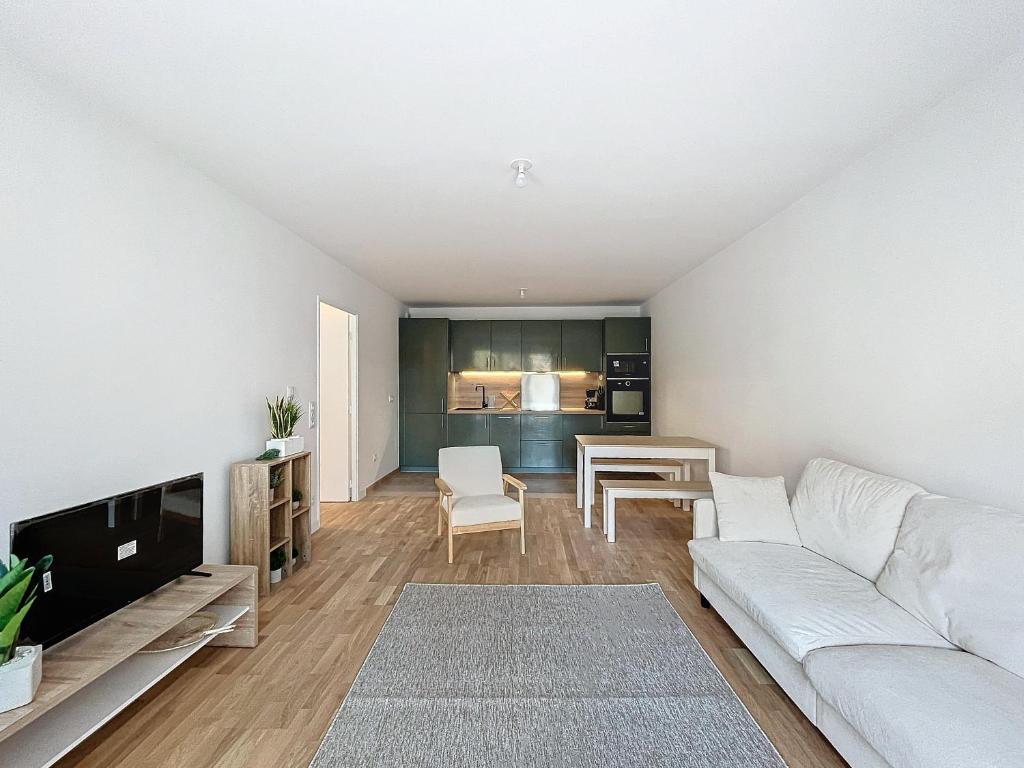 un salon avec un canapé blanc et une table dans l'établissement Le Bleuet - Proche Paris - 2 BDR - Terrasse, à Bezons