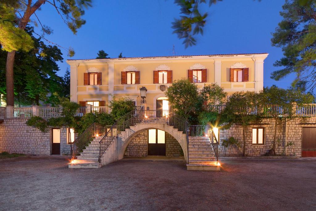 a large building with a staircase in front of it at Affittacamere Villa Gigli in Sirolo