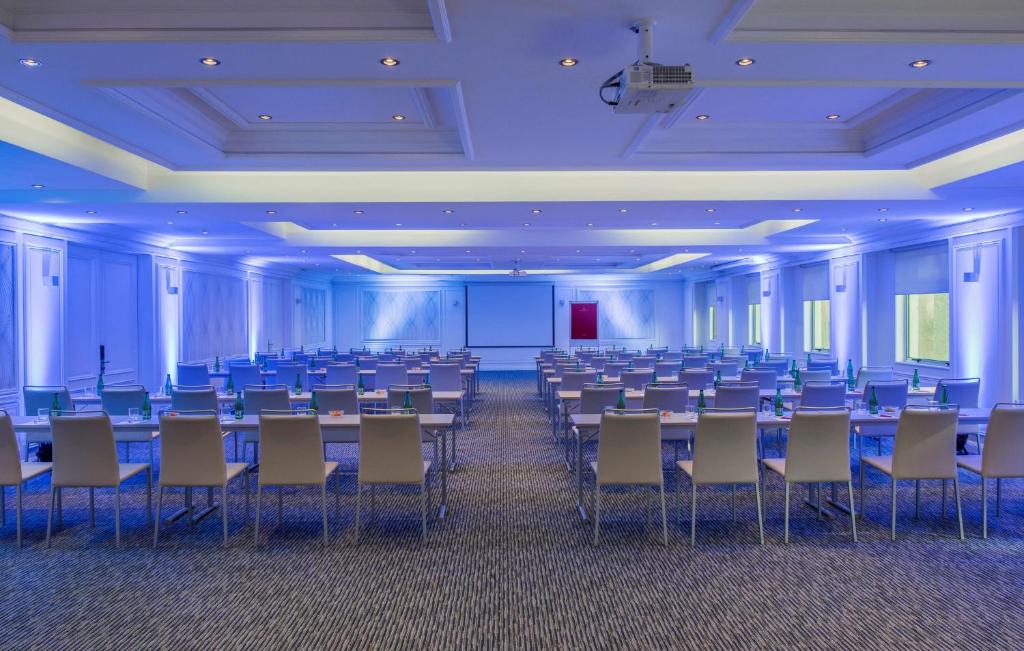 a large room with rows of tables and chairs at NH Collection Plaza Santiago in Santiago