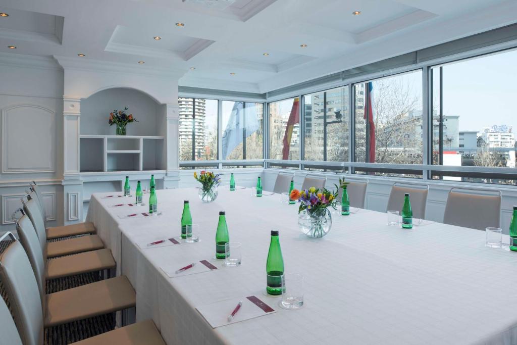 a large conference room with a long table with green bottles at NH Collection Plaza Santiago in Santiago