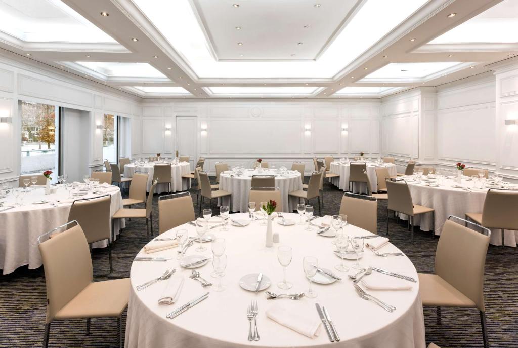 a banquet room with white tables and chairs at NH Collection Plaza Santiago in Santiago