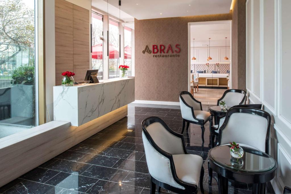 a bar with tables and chairs in a restaurant at NH Collection Plaza Santiago in Santiago