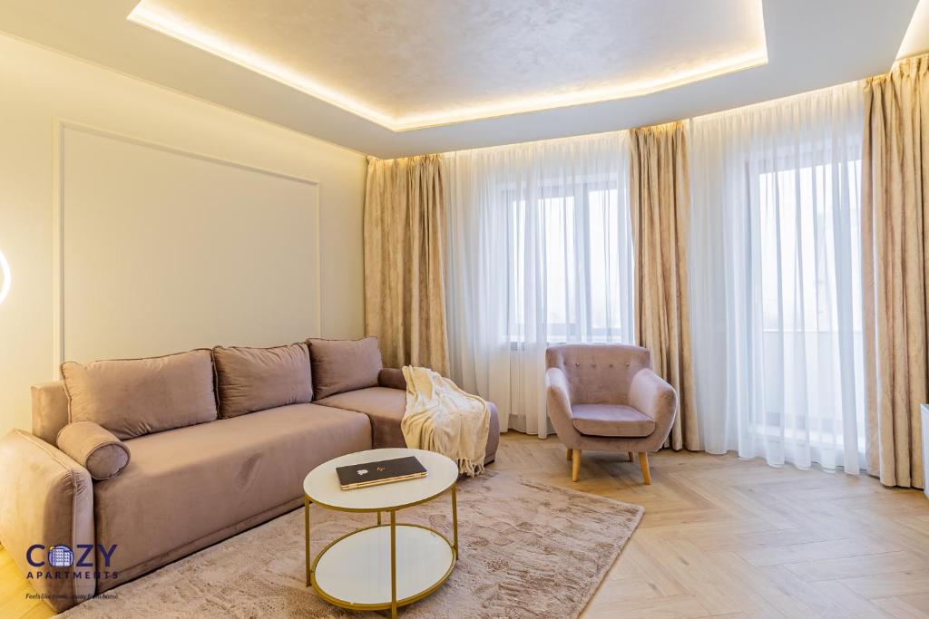 ein Wohnzimmer mit einer Couch und einem Sessel in der Unterkunft COZY Luxury Collection - PREMIUM APARTHOTEL in Braşov