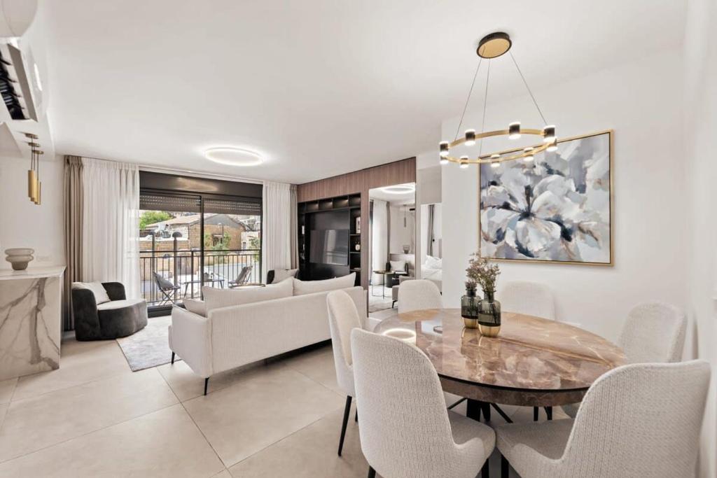 une salle à manger et un salon avec une table et des chaises dans l'établissement Luxury 3 BDR In The Heart Of Jerusalem By Isrentals, à Jérusalem