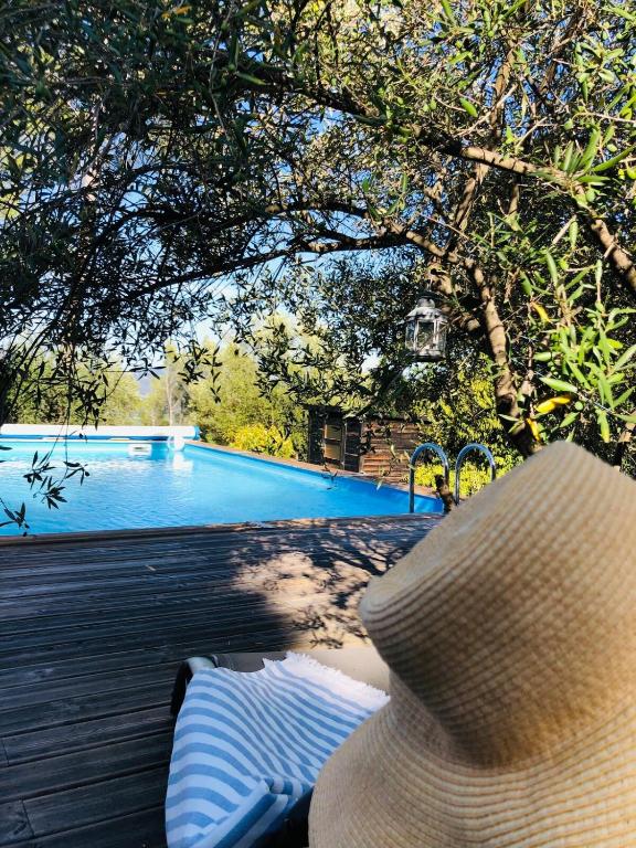 - un chapeau assis sur un banc à côté d'une piscine dans l'établissement Maison au cœur du Var, à Sillans-la-Cascade