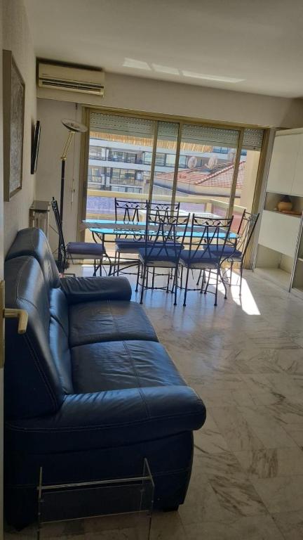 un salon avec un canapé, une table et des chaises dans l'établissement 2 Bedroom Martinez Side, à Cannes