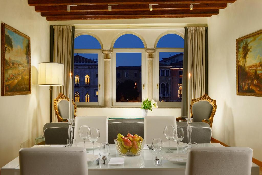 a dining room with a table and chairs and a window at L'O Venezia Flat - WTB Hotels in Venice