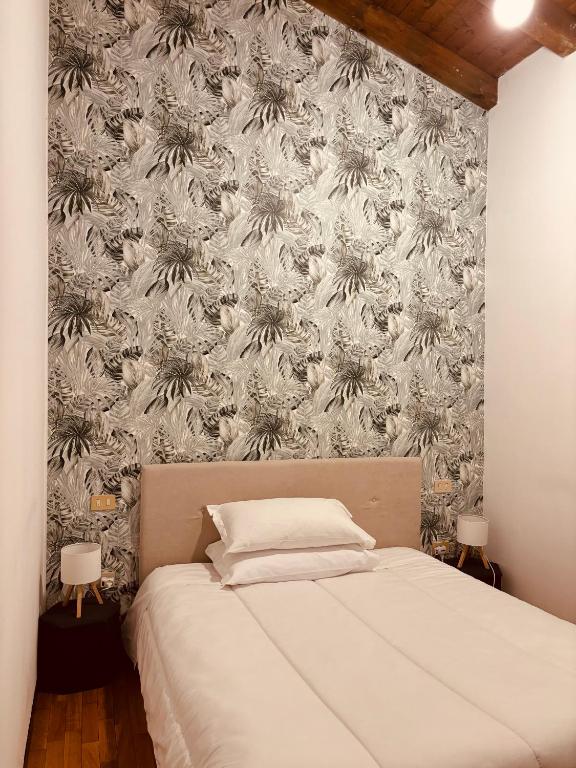 una camera con un letto e una parete con carta da parati di Capitolium Ad a Brescia