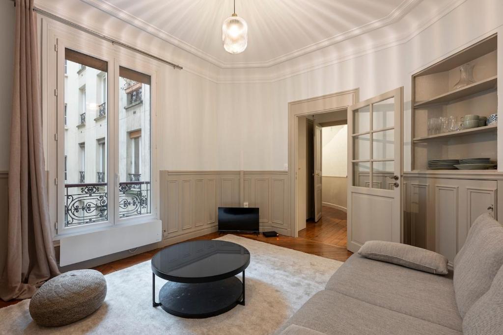 un salon avec un canapé et une table dans l'établissement Appartement Élégant et Spacieux dans le 8ème, à Paris