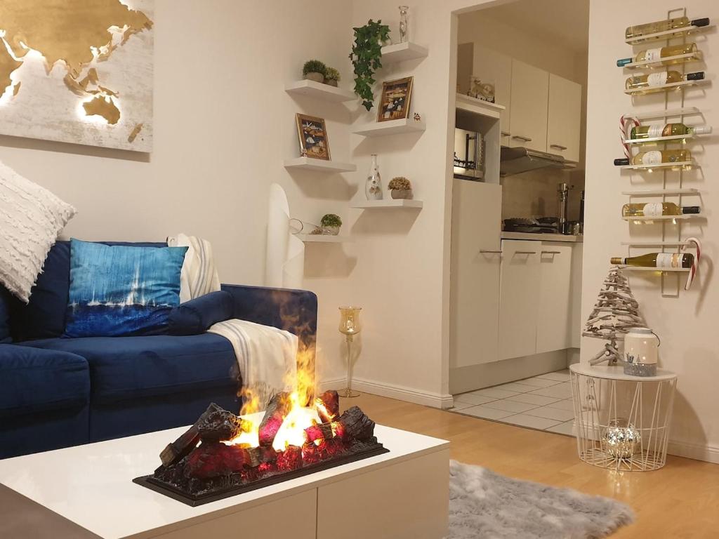 グリュックスブルクにあるModern und am Strand Balkon,PPのリビングルーム(青いソファ、ファイヤーピット付)