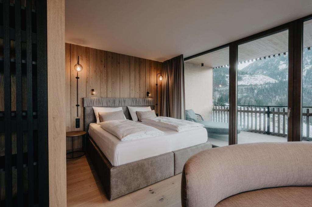 a bedroom with two beds and a balcony at Hotel Berghof - St Johann in Salzburg in Sankt Johann im Pongau