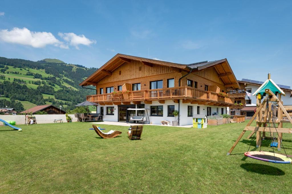 una casa grande con un patio con parque infantil en M&M Appartements Brixental, en Westendorf