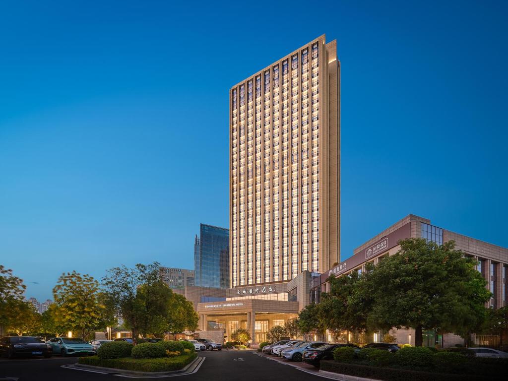a rendering of a tall building with cars parked in front at Dongguan DongCheng International Hotel - Free shuttle buses for executive room guests during Canton Fair in Dongguan