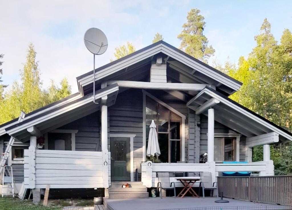a small house with a porch and a table at Villa Lähde Päijätsalon järvimaisemassa in Sysmä