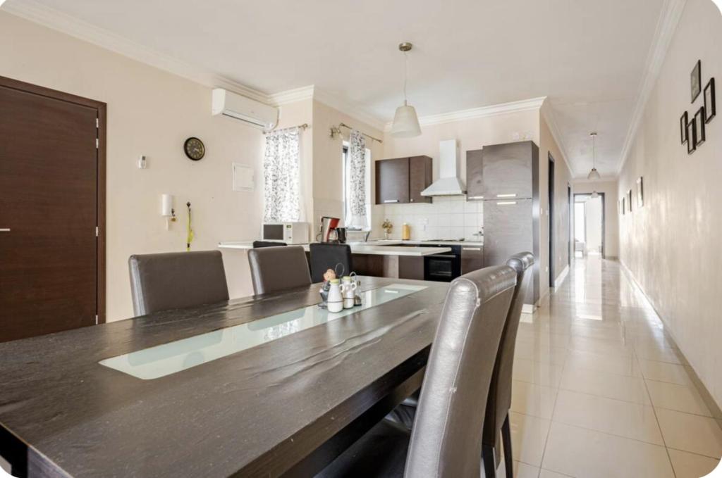 a kitchen and dining room with a table and chairs at Elegant central apartment in Sliema