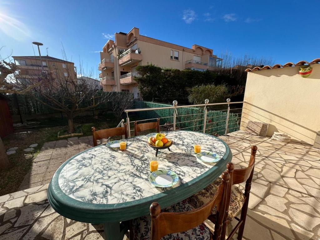 - une table verte avec un bol de fruits dans l'établissement Reym, à Valras-Plage