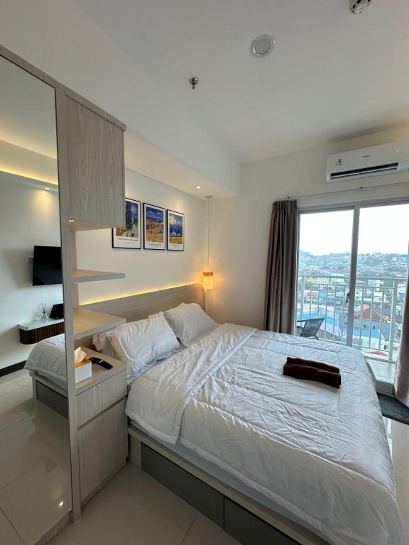 a bedroom with a large bed and a large window at Apartment Citra Plaza Nagoya Batam 10-27 in Jodoh