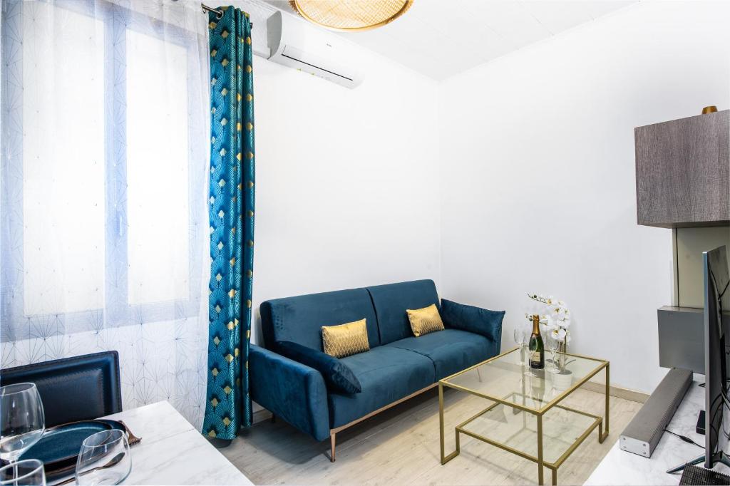 un salon avec un canapé bleu et une table dans l'établissement DOUMER - Cosy deux pièces - Frontière Monaco, à Beausoleil
