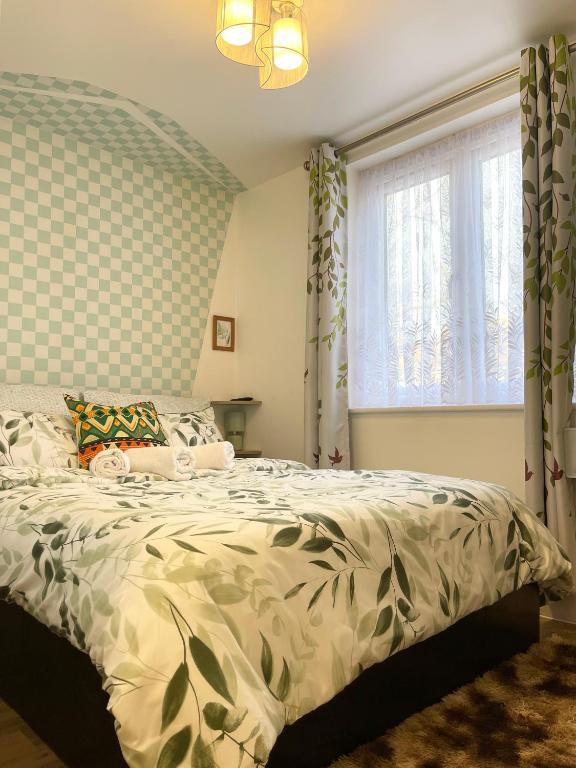 a bedroom with a bed and a window at Norwich 1st Floor Apartment in Goodmayes