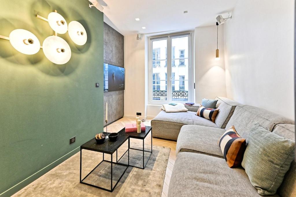 un salon avec un canapé et une table dans l'établissement Apartment Cosy & Design Montorgueil, à Paris