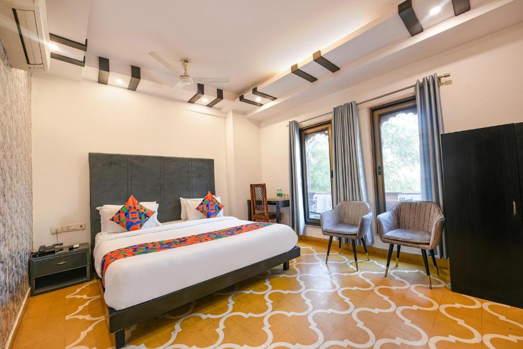 une chambre avec un grand lit et deux chaises dans l'établissement FabHotel The Heritage, à New Delhi