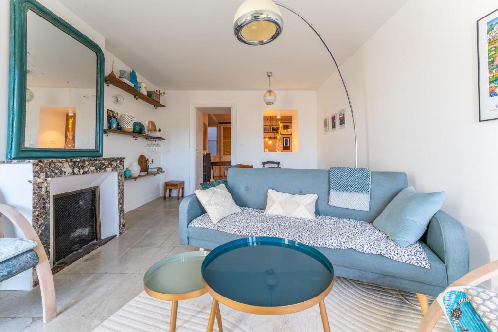 un salon avec un canapé bleu et une cheminée dans l'établissement Charmant T4 en plein cœur de Montpellier, à Montpellier