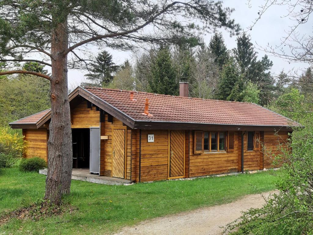 a log cabin with a garage and a tree at Ferienhaus Donau 31 Glückskäfer in Hayingen