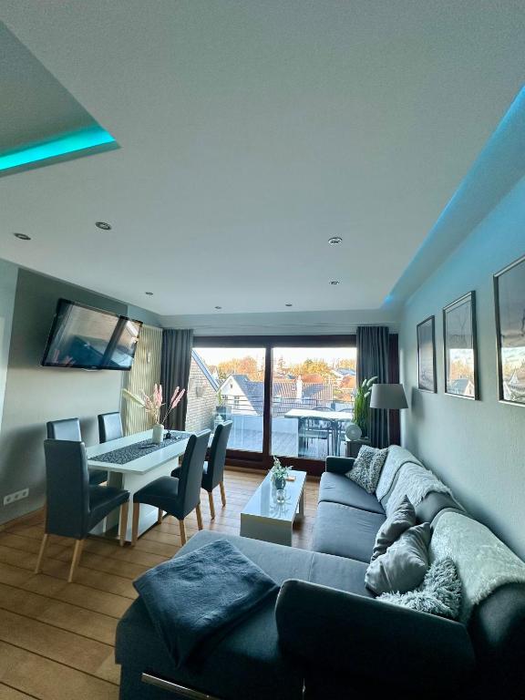 a living room with a couch and a table with chairs at Ferienwohnung Strandperle - nur 150m zum Strand in Scharbeutz