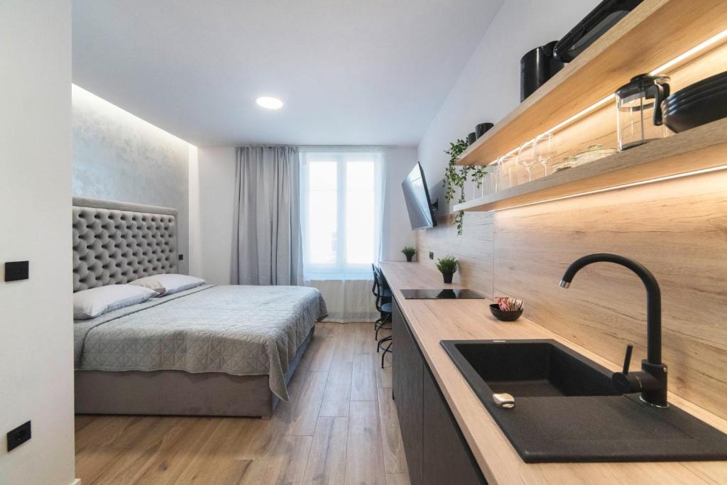 een keuken met een wastafel en een bed in een kamer bij Liberty Apartments, 3rd Floor, no elevator in Zagreb