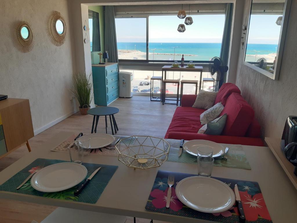 - un salon avec un canapé rouge et une vue sur l'océan dans l'établissement superbe appt face à la mer, wifi, à Canet