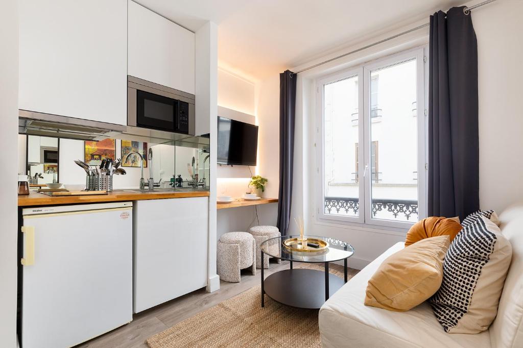un salon avec un canapé blanc et une cuisine dans l'établissement Cozy Studio - Eiffel Tower - Sleeps 2P, à Paris