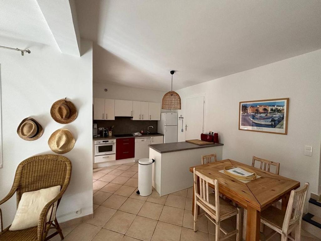 une cuisine et une salle à manger avec une table et des chaises dans l'établissement Mini-villa à 5 minutes de la plage de Santa Giulia, à Porto-Vecchio