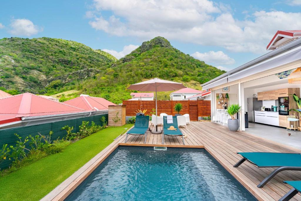an image of a backyard with a swimming pool and a house at Villa Topaze in Terre-de-Haut