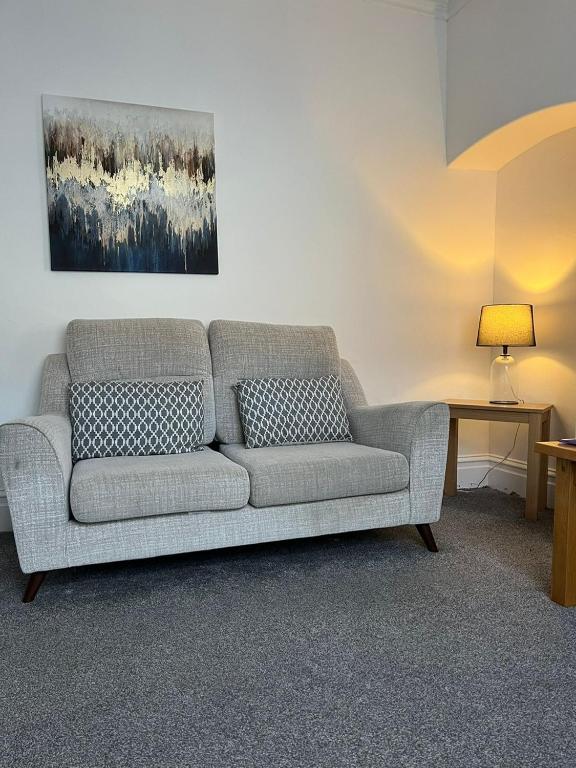 a gray couch in a living room with a painting at Alston House in Hartlepool
