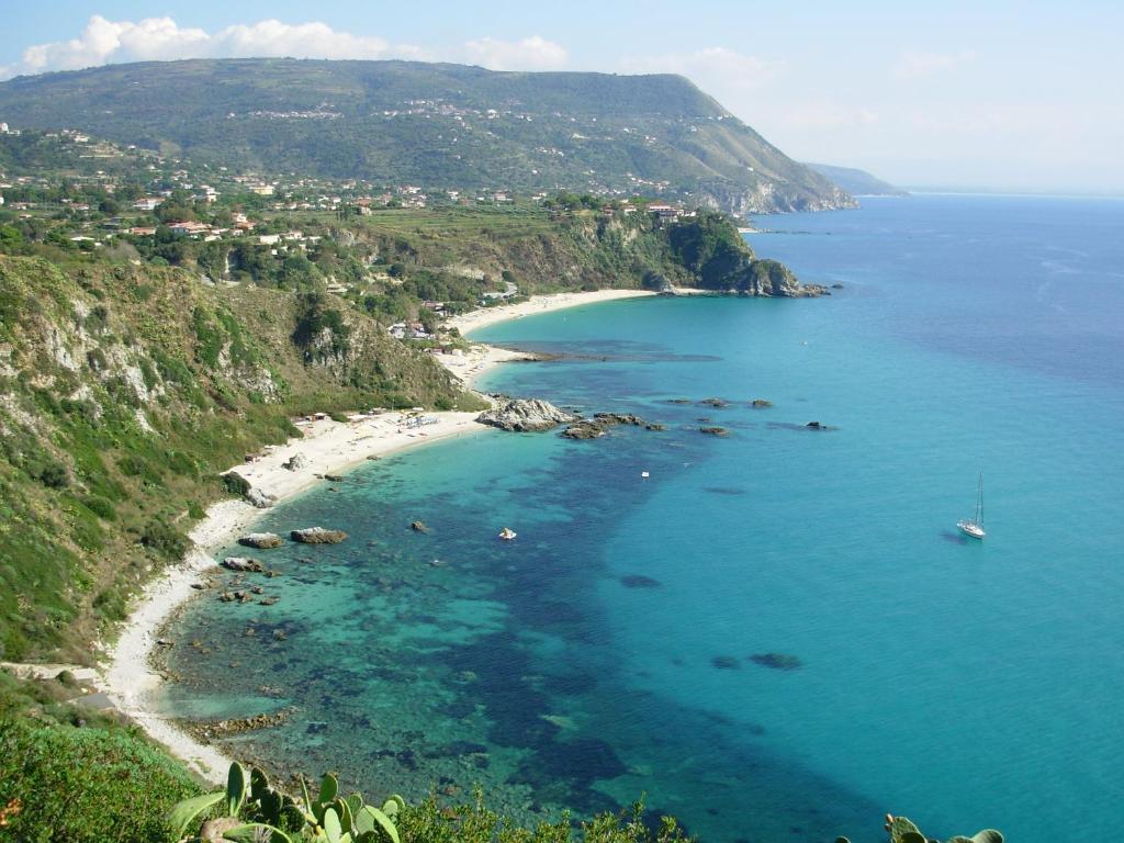 
a beach with a large body of water at Residence Hotel La Taverna in Capo Vaticano
