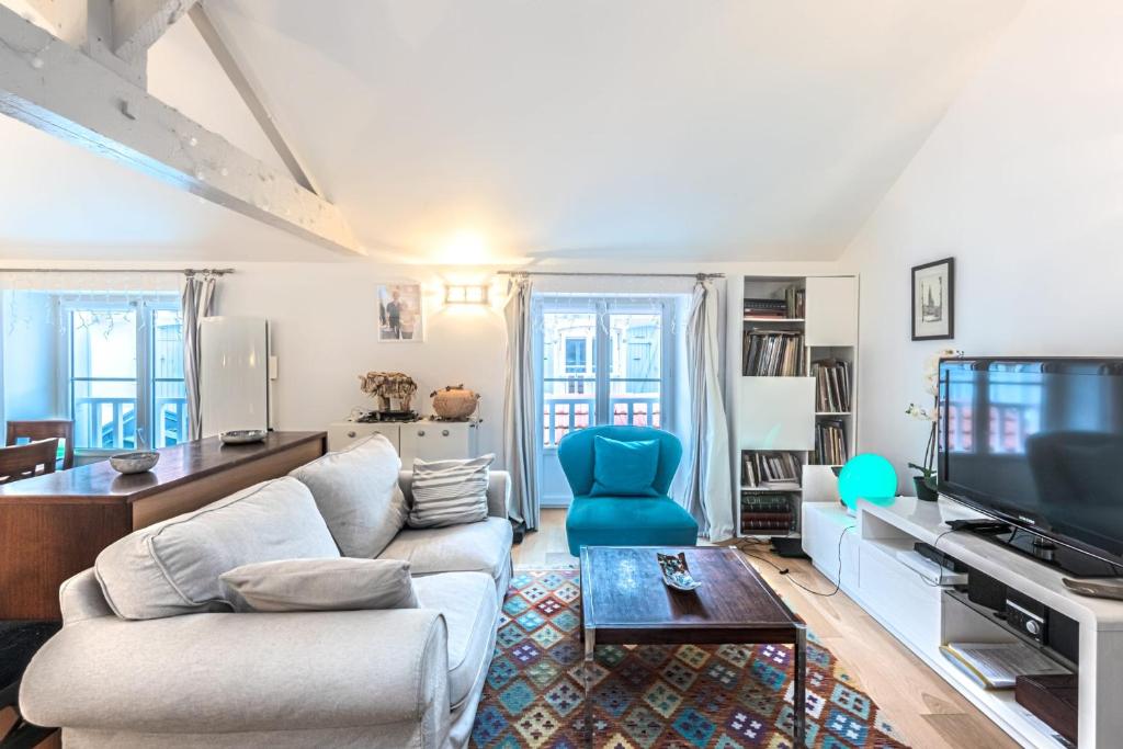 un salon avec un canapé et une télévision dans l'établissement Appartement Verdun - Welkeys, à Biarritz