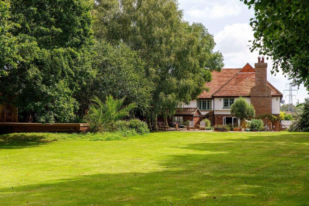 a house with a green lawn in front of it at Tranquil Luxe in Country Cottage in Bosham