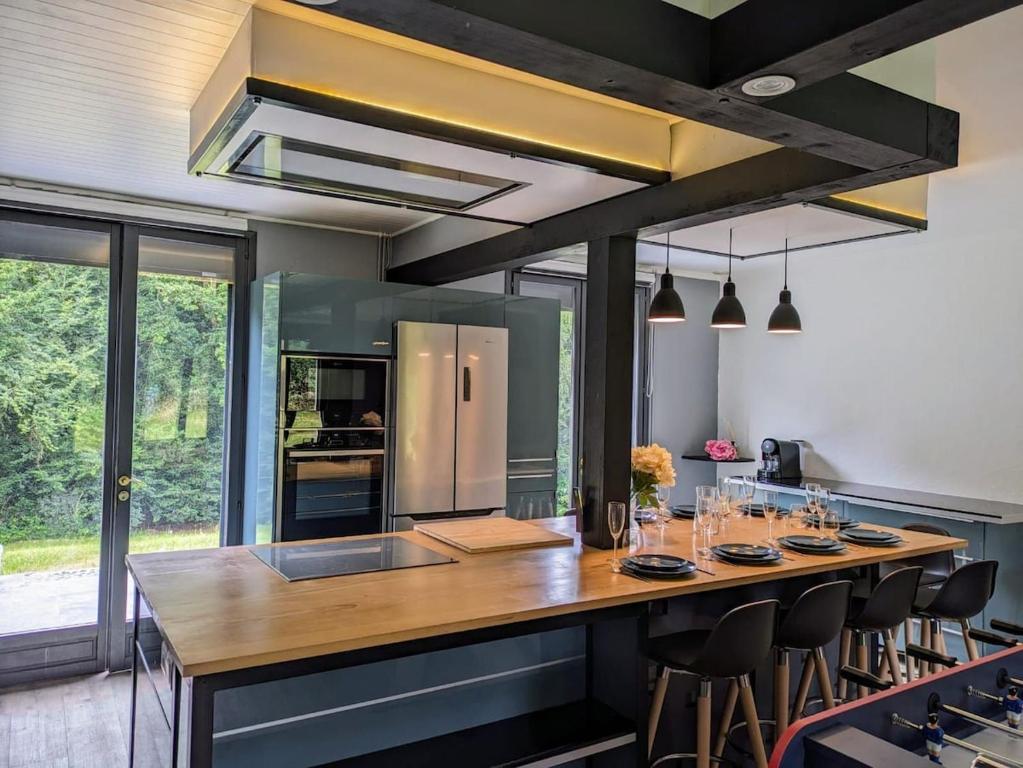 a kitchen with a large island with a wooden counter top at Peaceful house - SPA - Babyfoot - Forest in Ablon