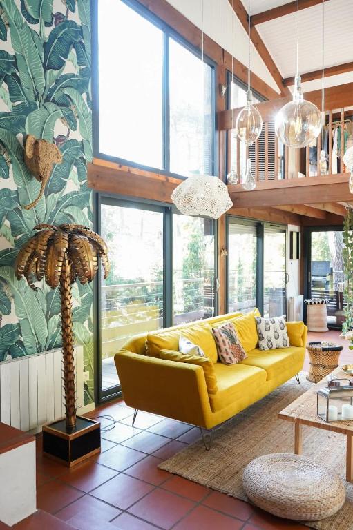 un salon avec un canapé jaune et une table dans l'établissement La Villa Tropicool, à Lège-Cap-Ferret