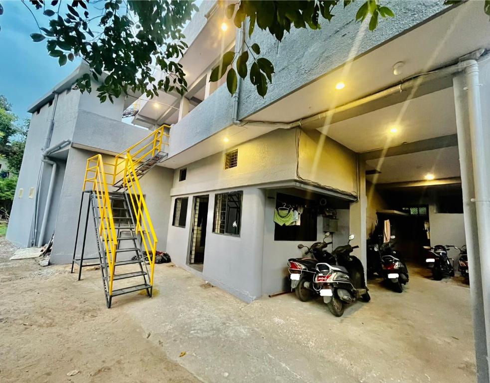 a garage with motorcycles parked outside of a building at Beds & Boys Hostel in Nagpur