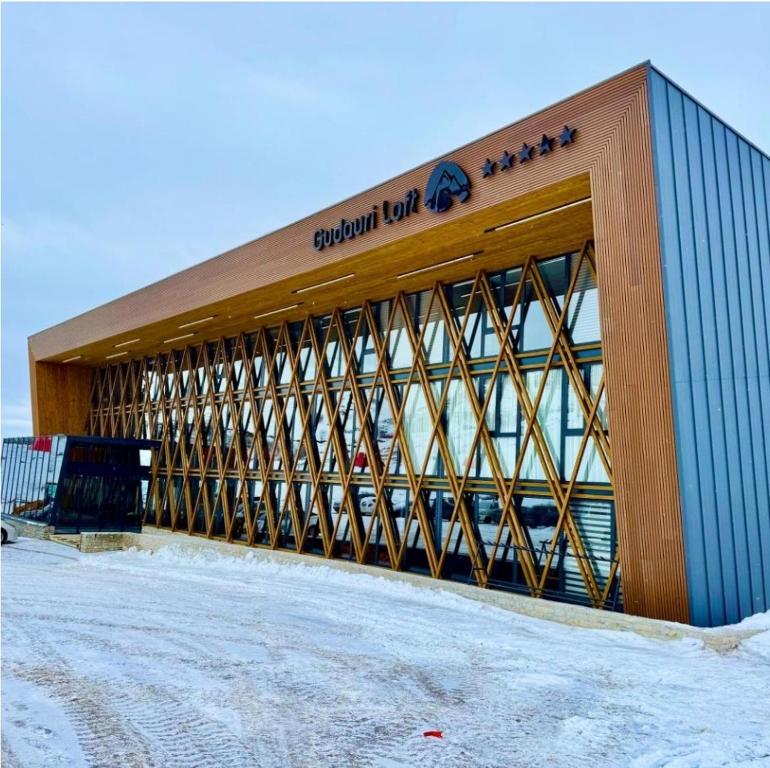 a building with a sign on the front of it at Ski in Ski out Tiamo Apartment 302-303 at Gudauri loft hotel in Gudauri