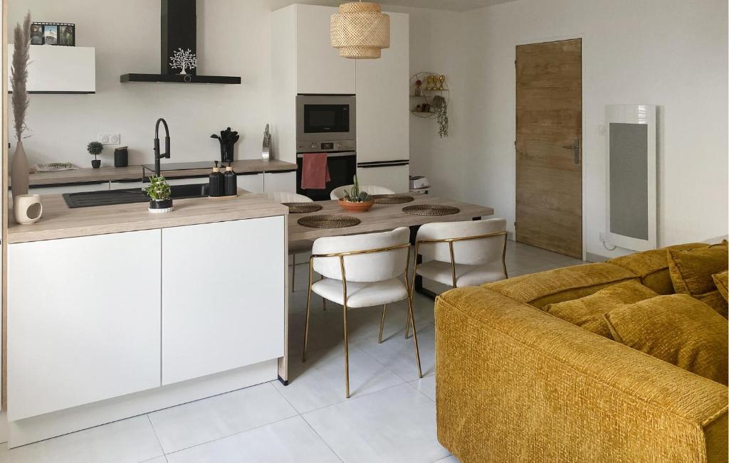 a kitchen and living room with a table and a couch at Jolie Maison in Pornic